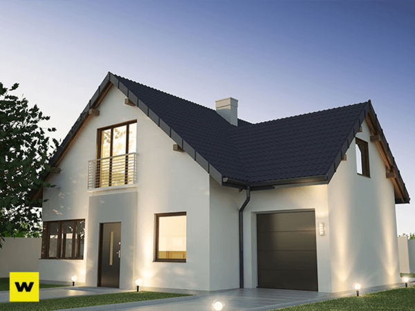 Modernes Einfamilienhaus mit Satteldach und Garage bei Abenddämmerung im Grünen.